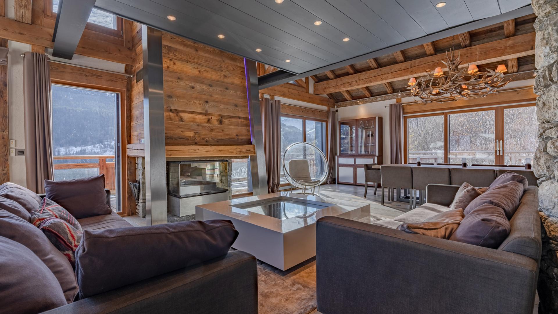 Salon avec cheminée et vue sur la table à manger du Chalet Apsara à Méribel