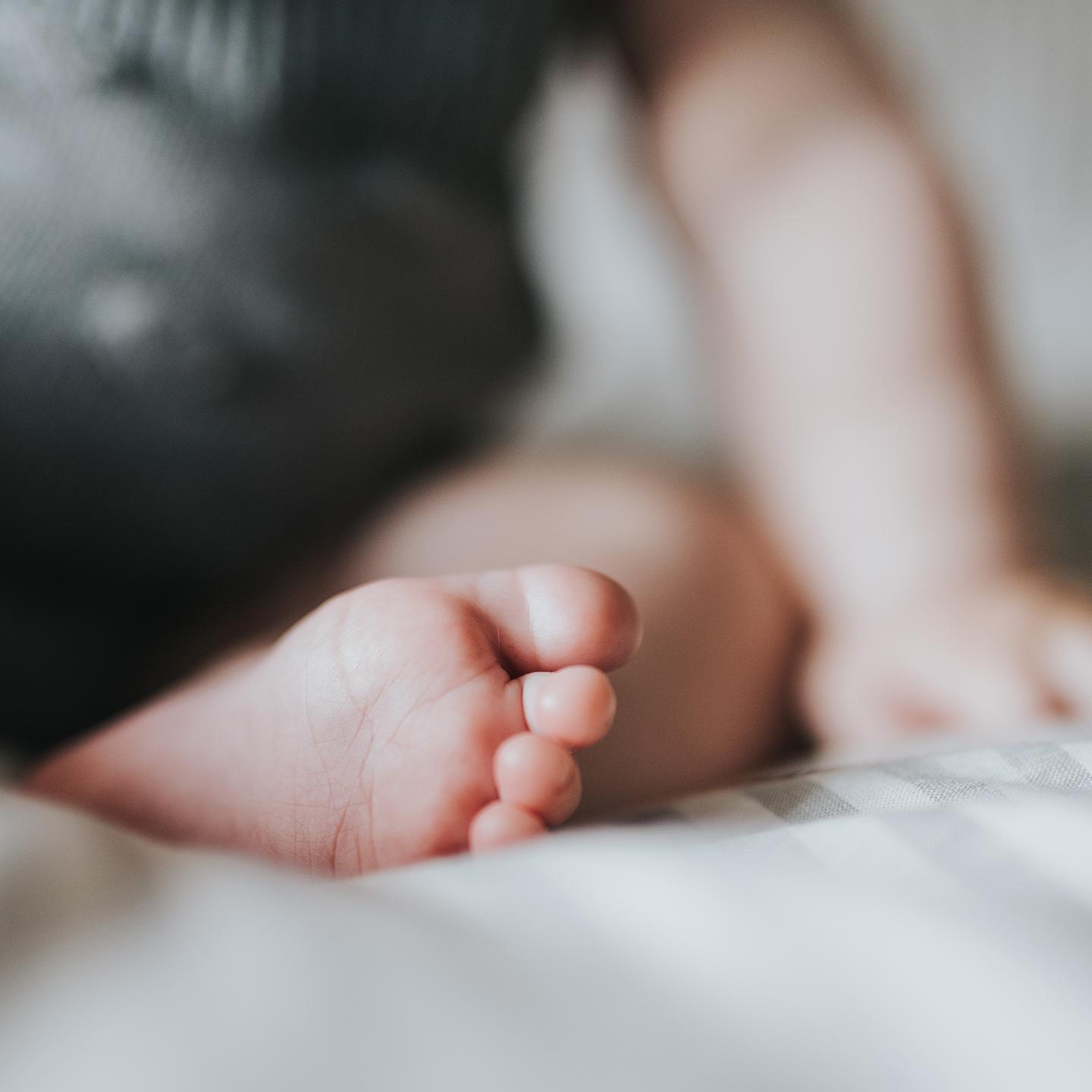 Un bébé est assis sur un lit