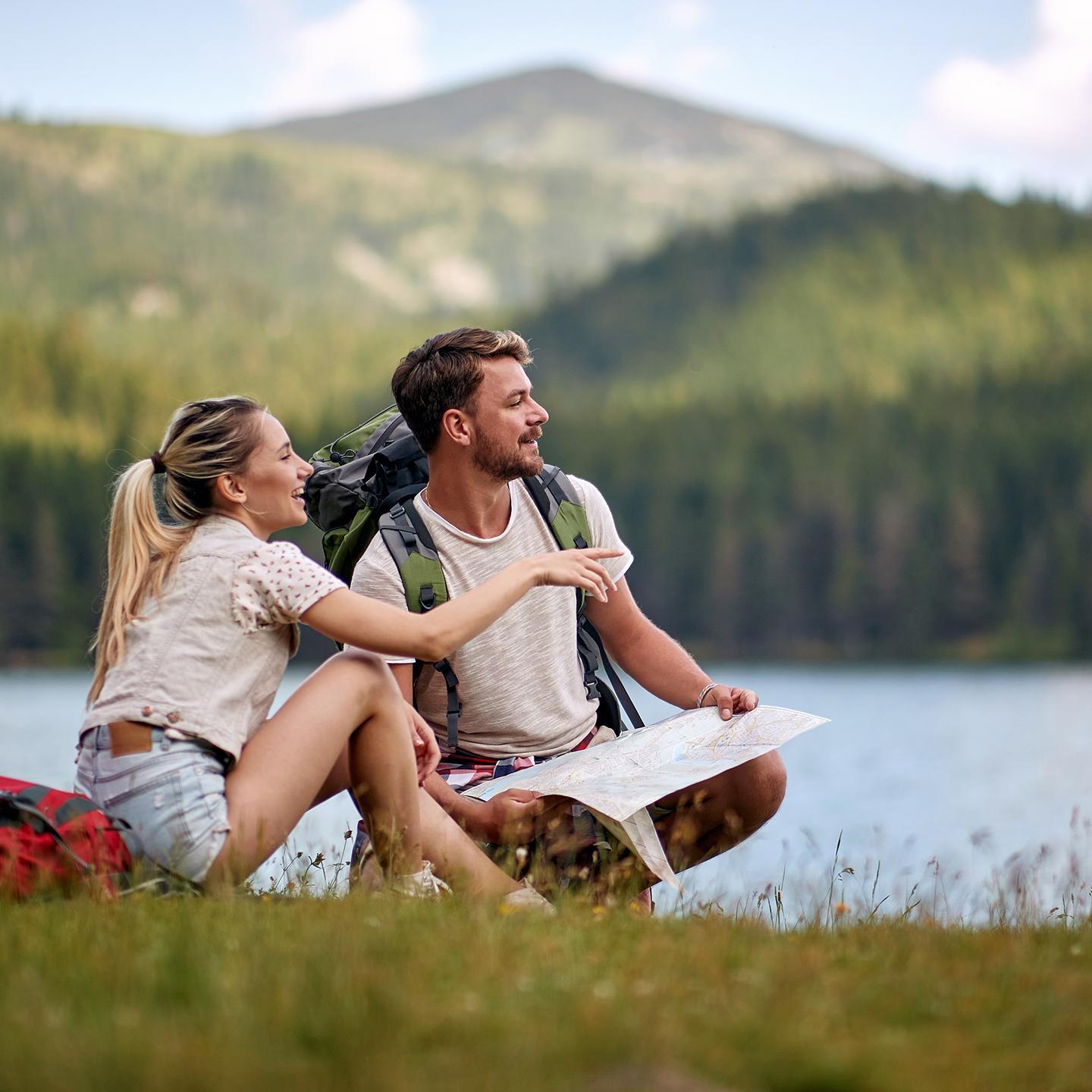 Couple de randonneurs en pause près d’un lac de montagne, en été