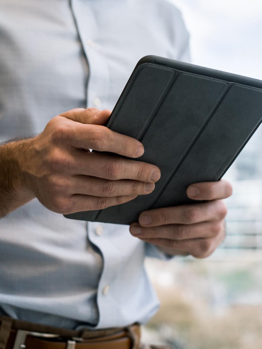 Un homme en chemise est en train de naviguer sur sa tablette