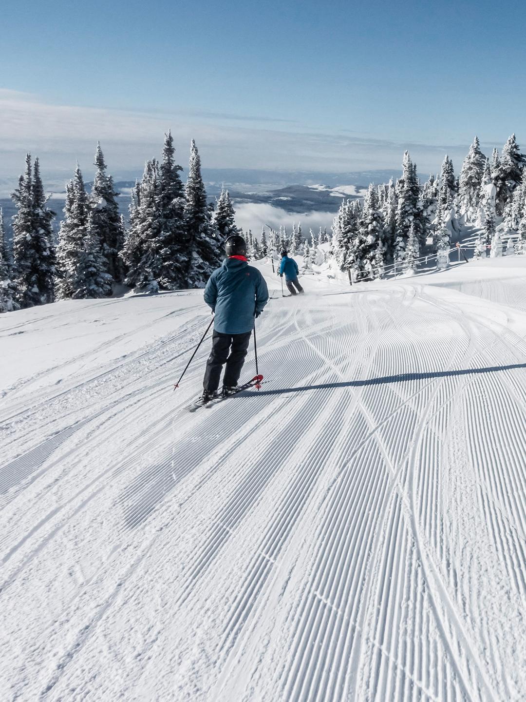 Trois personnes sont en train de descendre une piste à ski