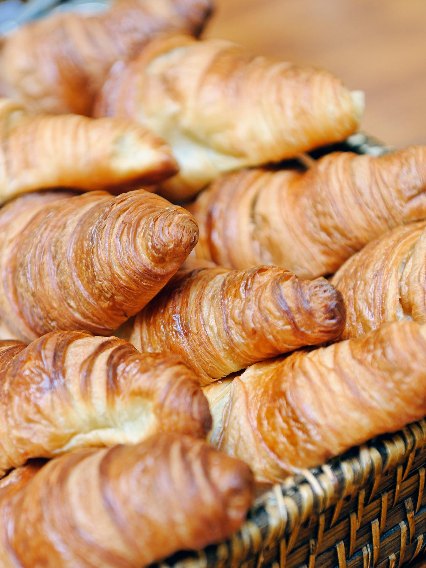 Des croissants sont superposés dans un panier bien rempli