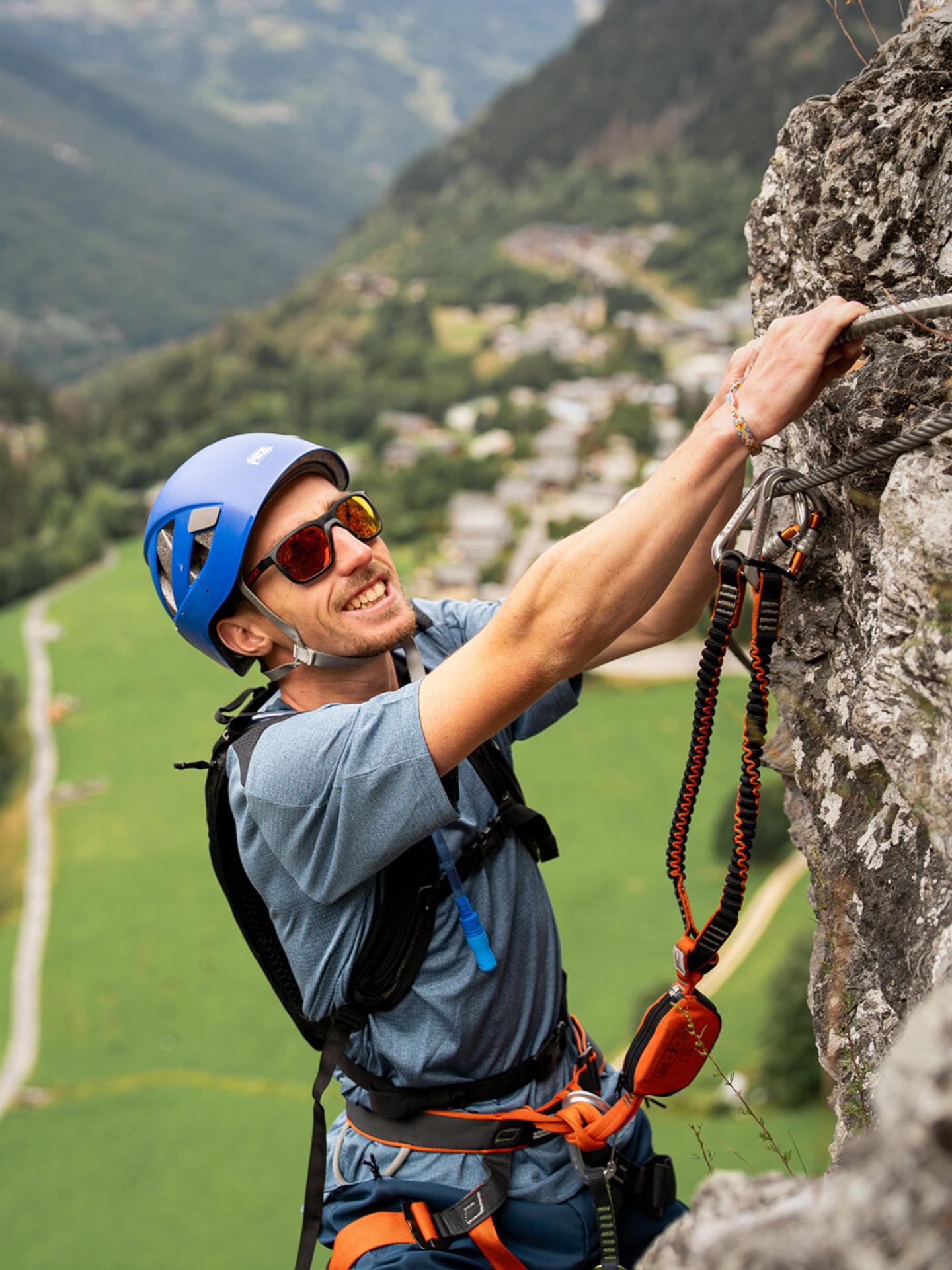 Personne pratiquant une via ferrata à La Plagne sur une paroi rocheuse
