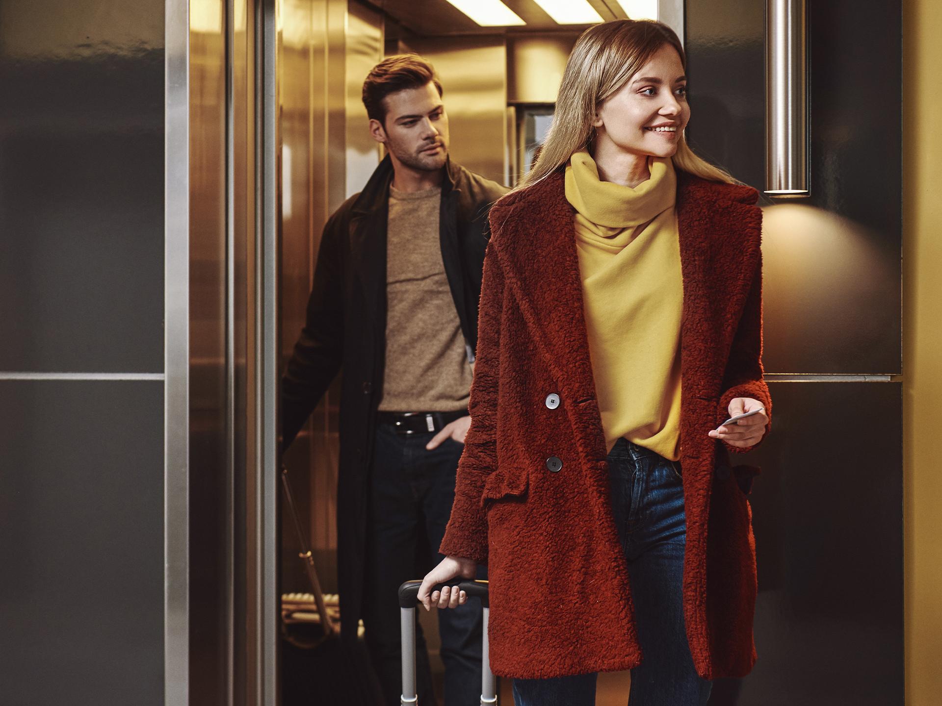 Couple sortant d'un ascenseur 