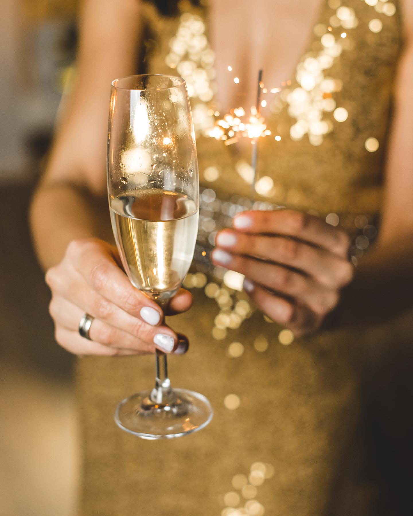 Une femme porte un verre de champagne à la main