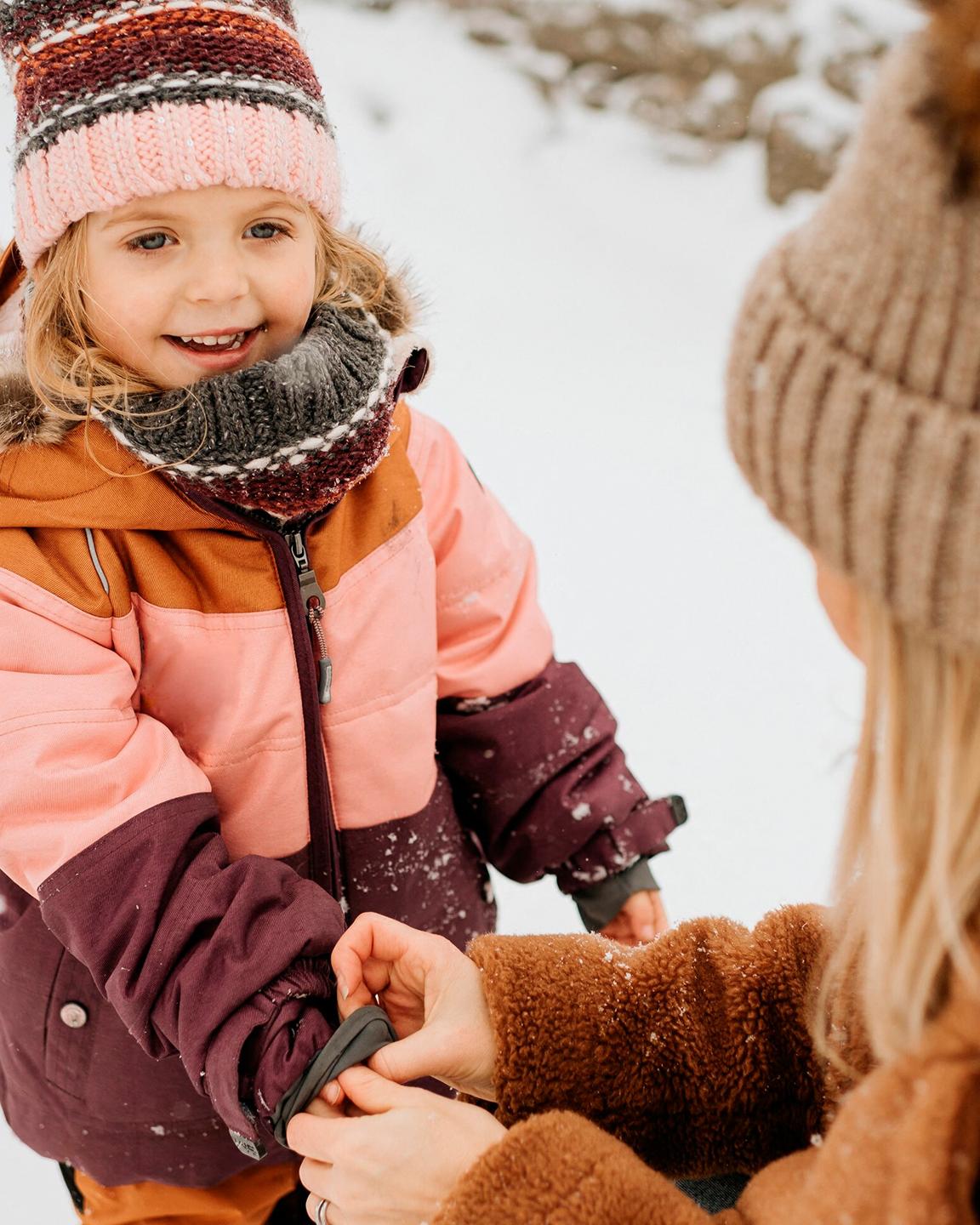 Une fillette et sa mère jouent dans la neige