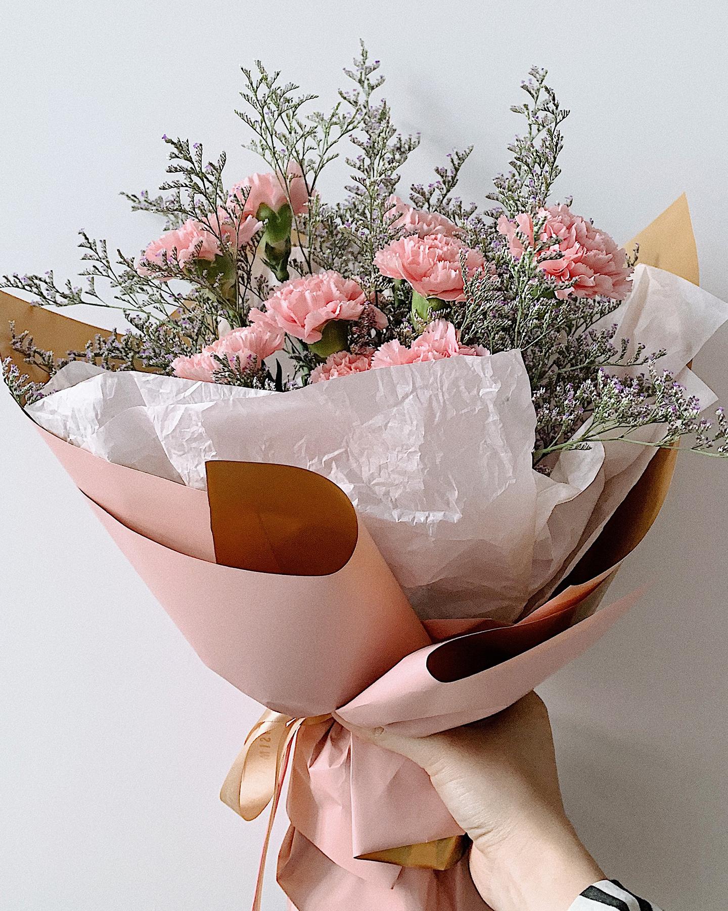 Un bouquet de fleurs est tendu par une main