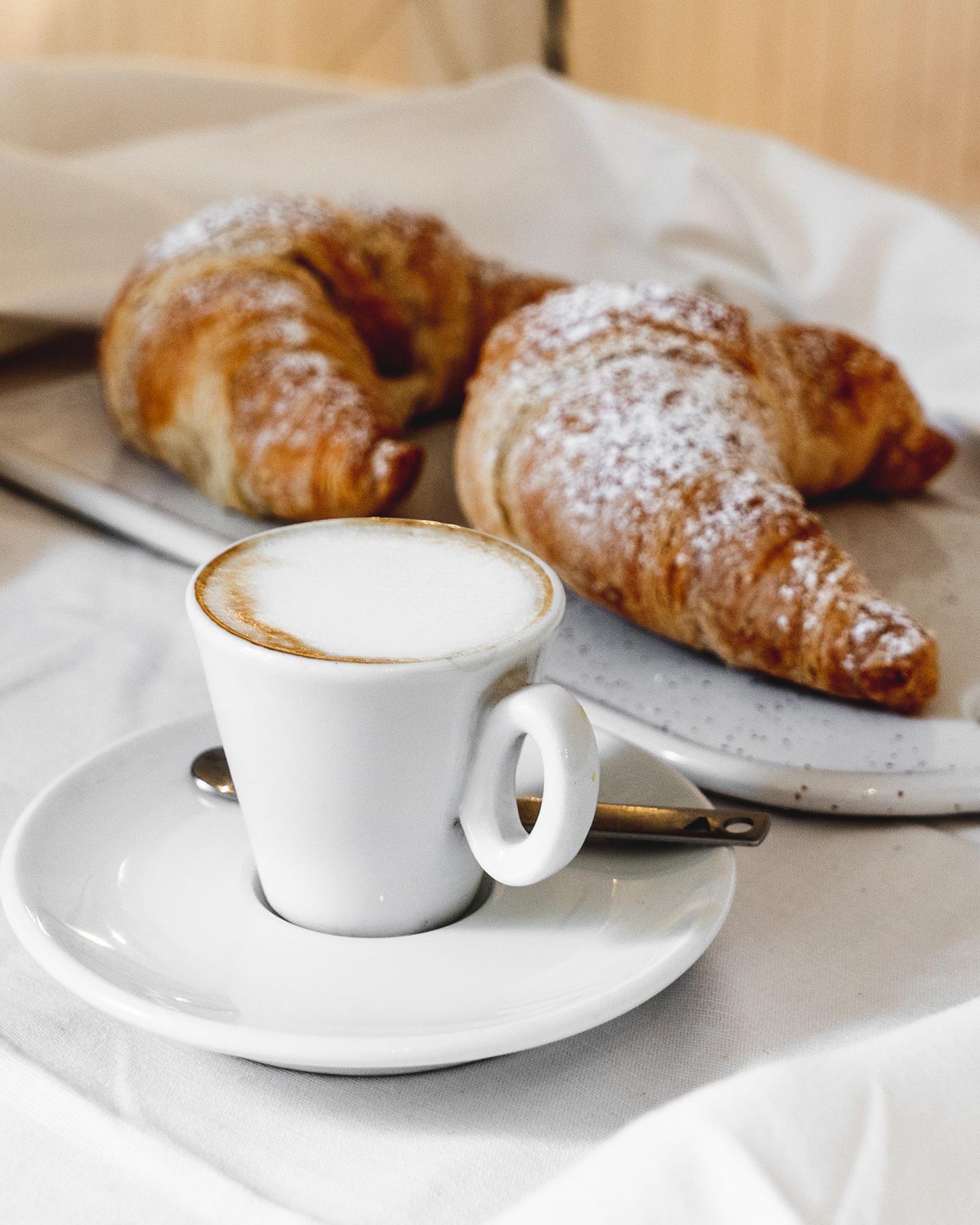 Un café est des croissants sont posés sur une table