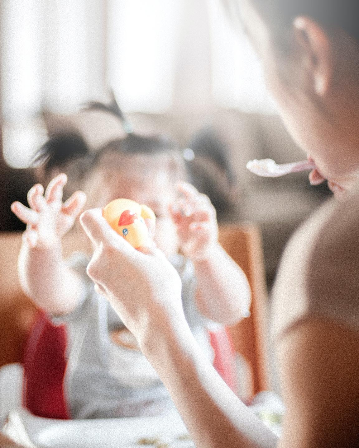 Une maman donne à manger à son enfant dans sa chaise haute