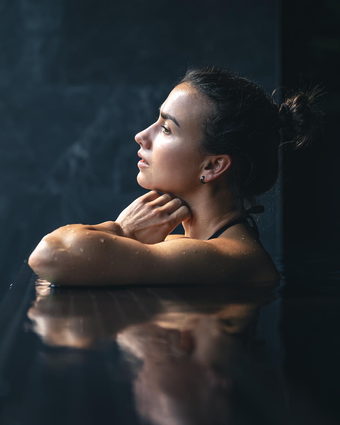 Une femme est en train d regarder par la fenêtre de la piscine du Spa Montagnes du Monde®