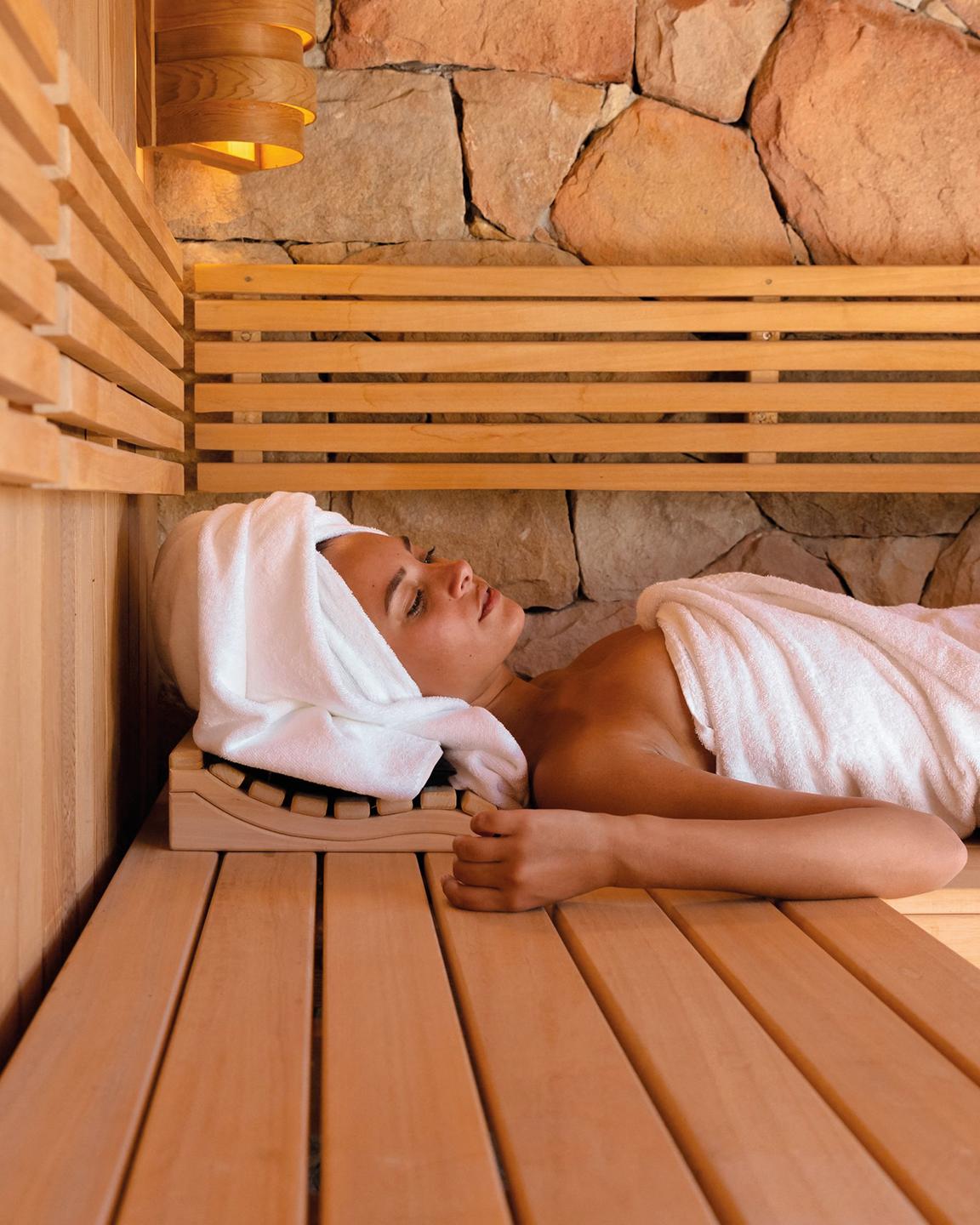 Une femme est allongée et se détend dans un sauna