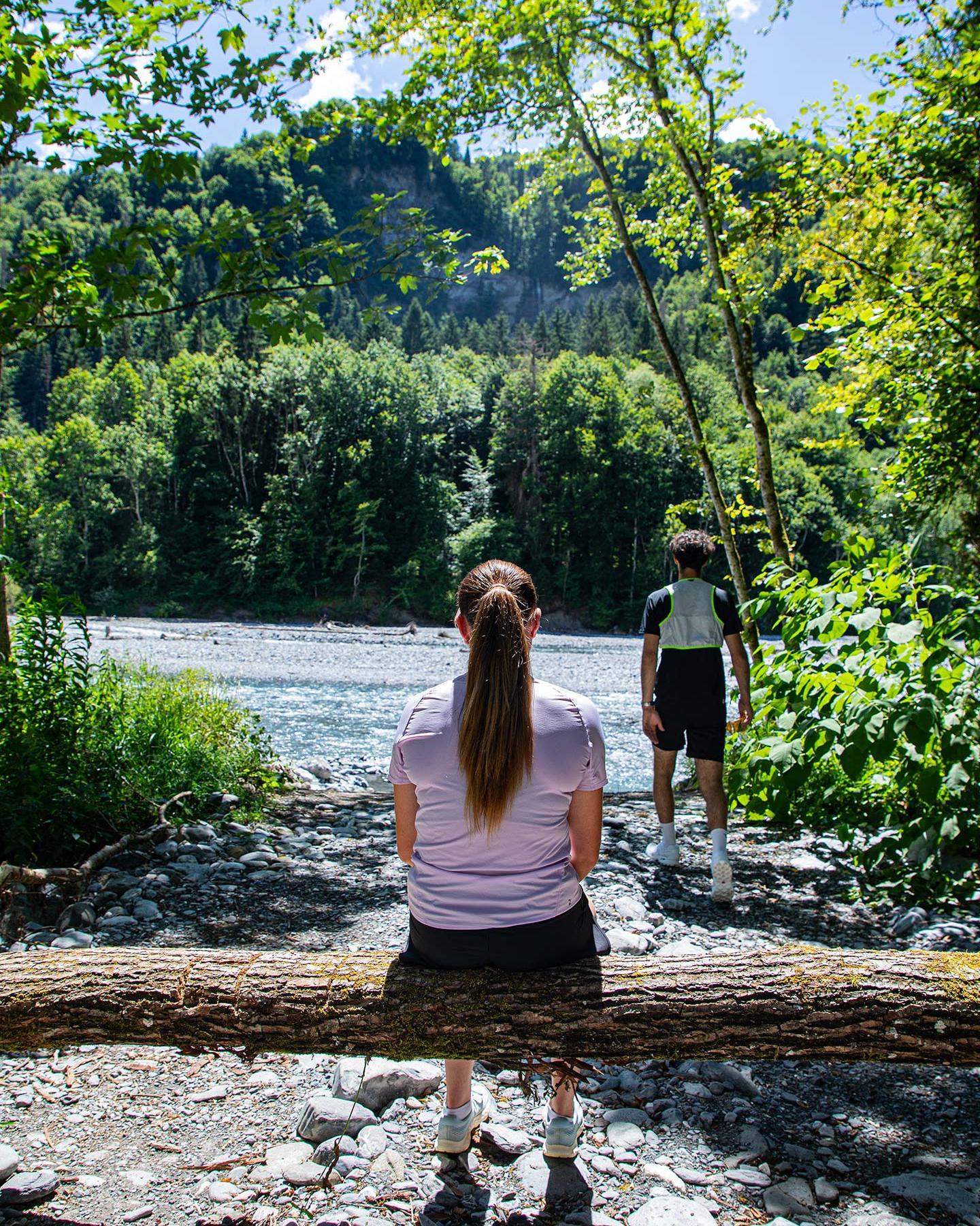 Couple en randonnée sportive faisant une pause au bord d’une rivière de montagne