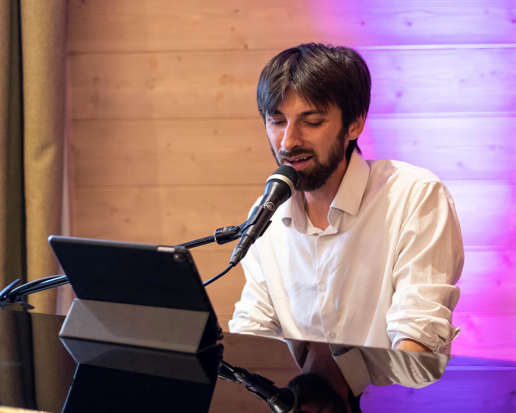 Un homme est en train de jouer du piano et de chanter en même temps au M'bar