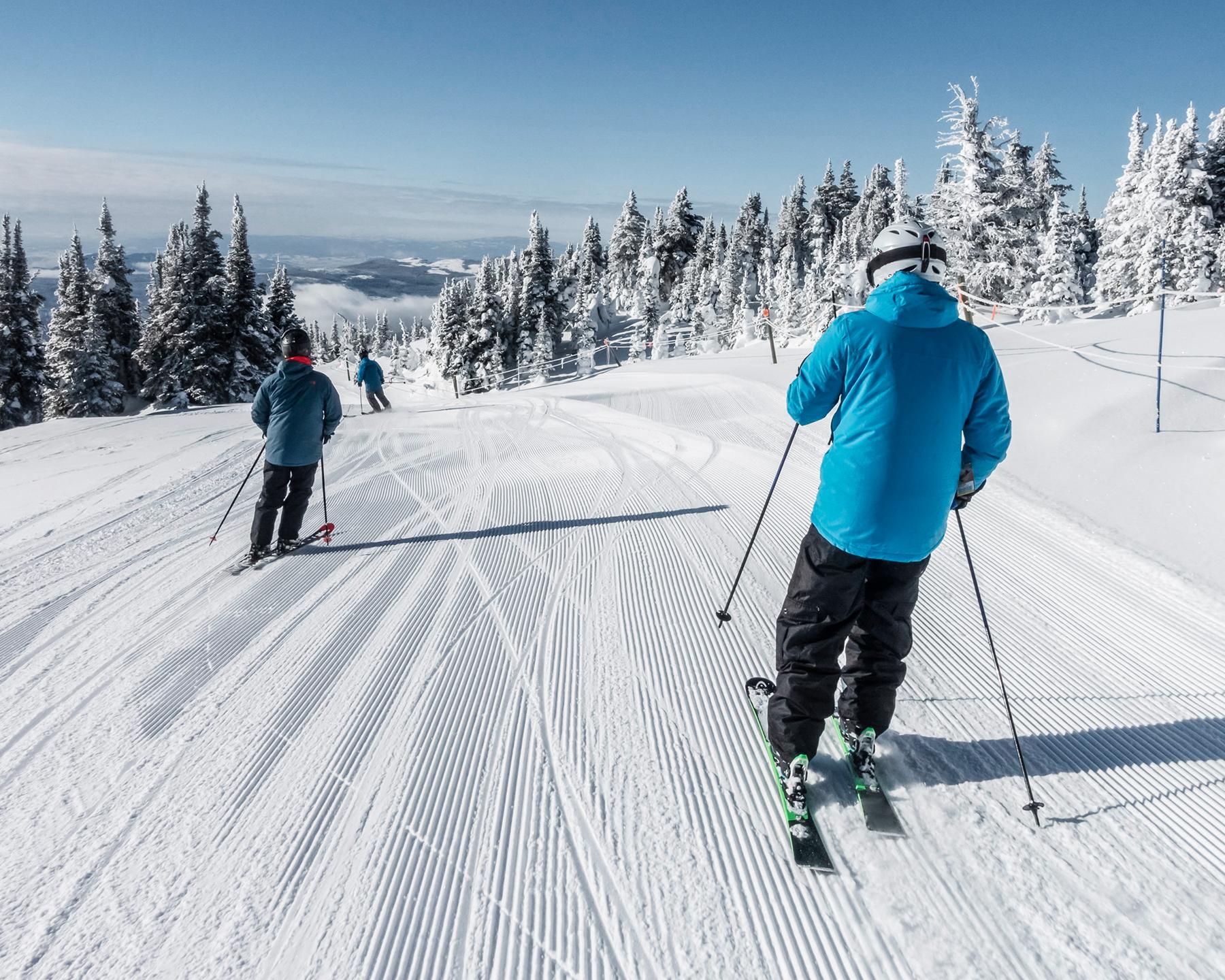 Trois personnes sont en train de descendre une piste à ski