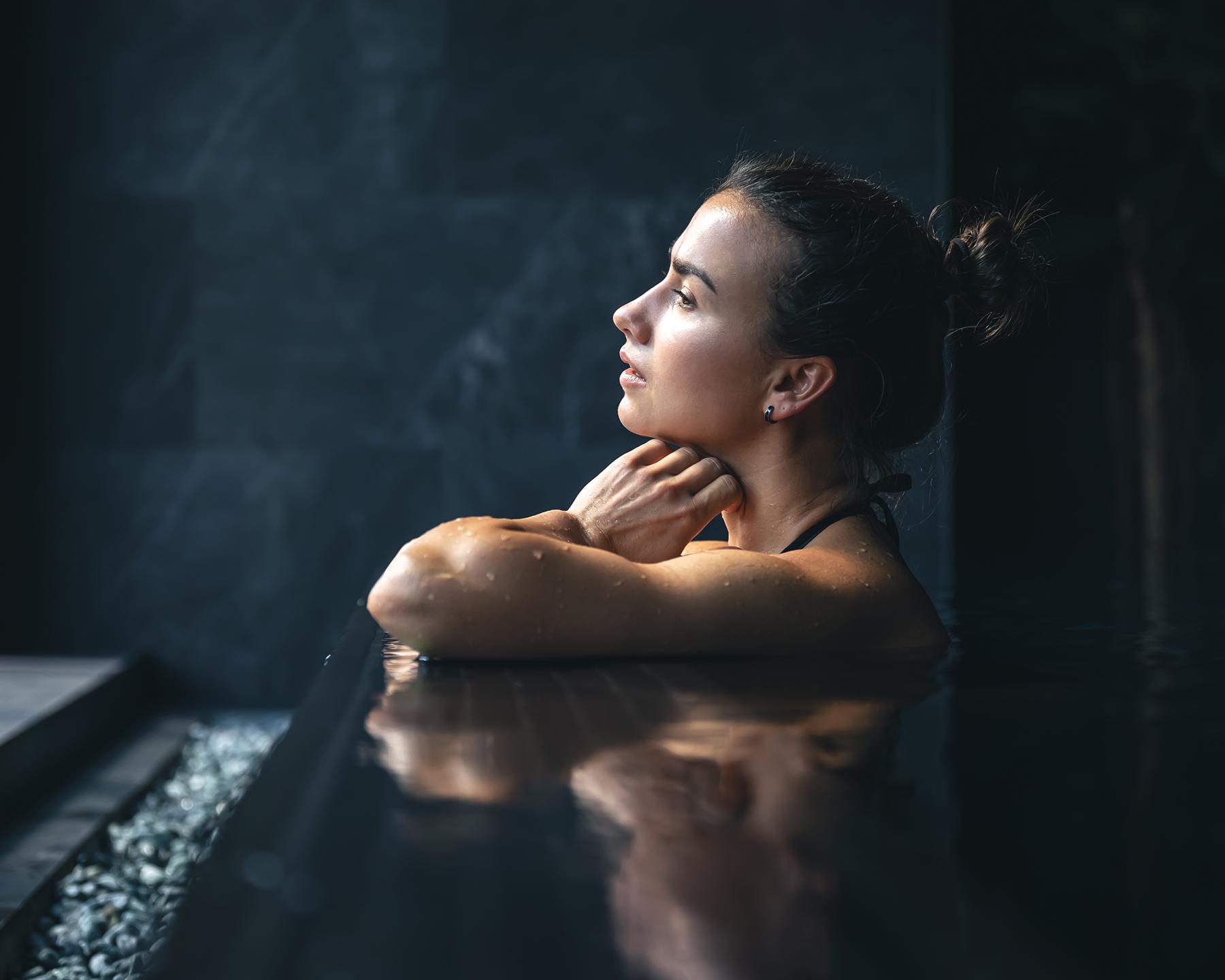 Une femme est en train d regarder par la fenêtre de la piscine du Spa Montagnes du Monde®