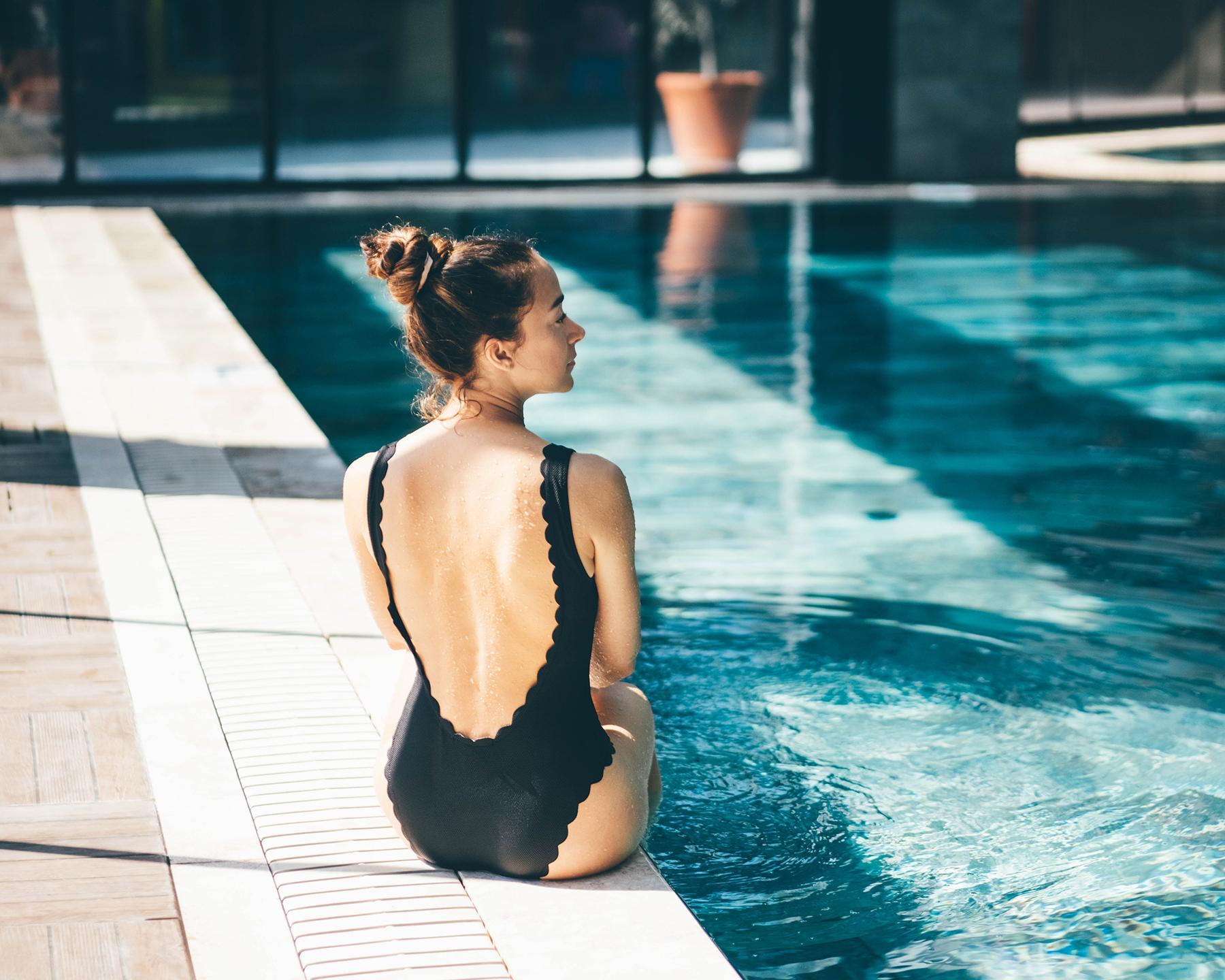 Femme qui se détend au bord d'une piscine