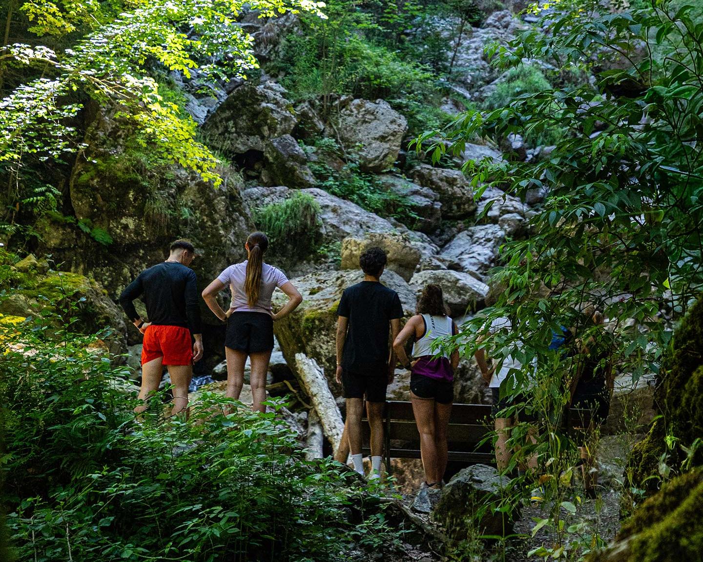 Groupe de sportifs faisant une pause devant une cascade de montagne dans le cadre du programme MGM Sérénité