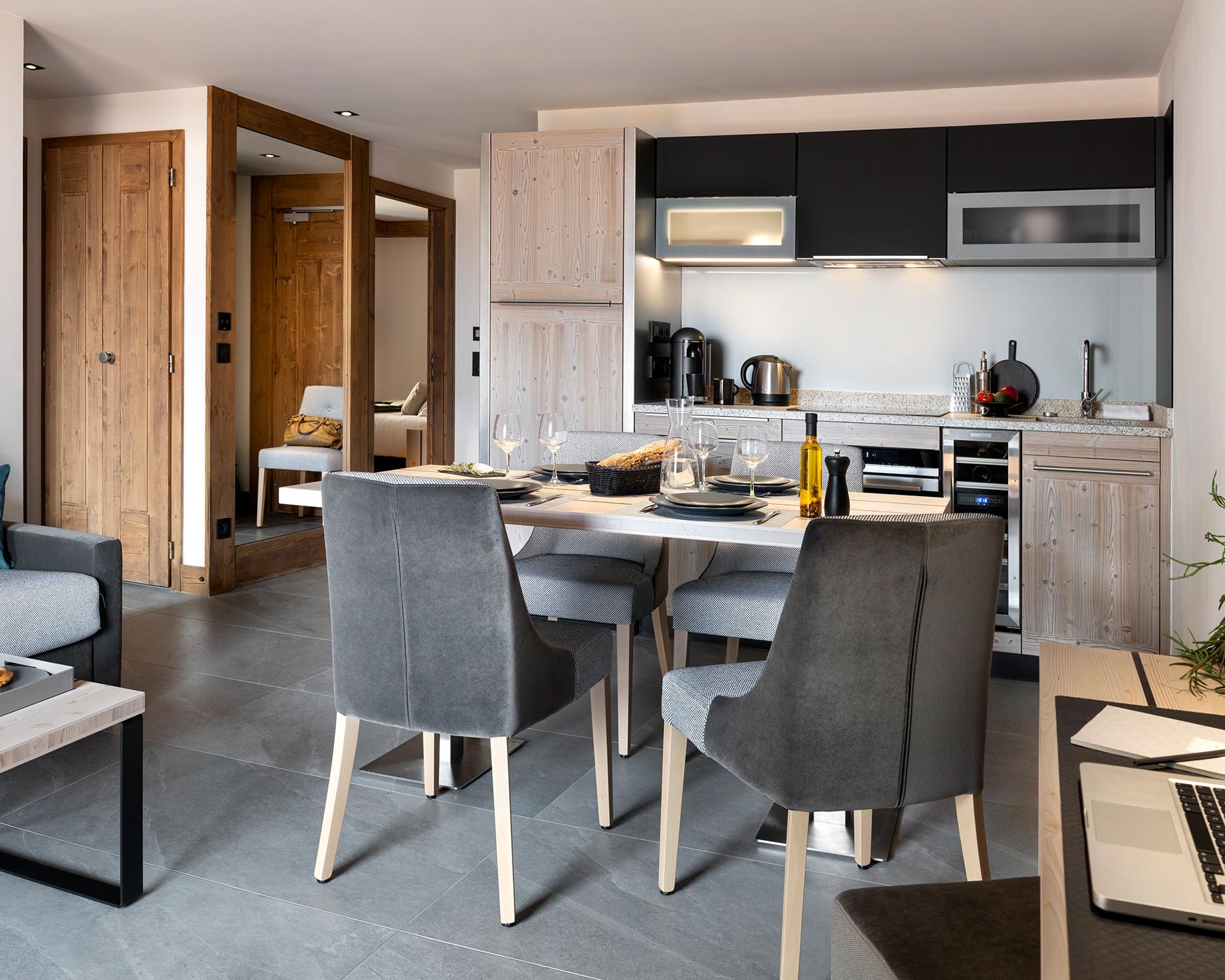 Pièce à vivre avec la cuisine en fond du 3P6 Prestige des Chalets Láska, situés aux Contamines-Montjoie