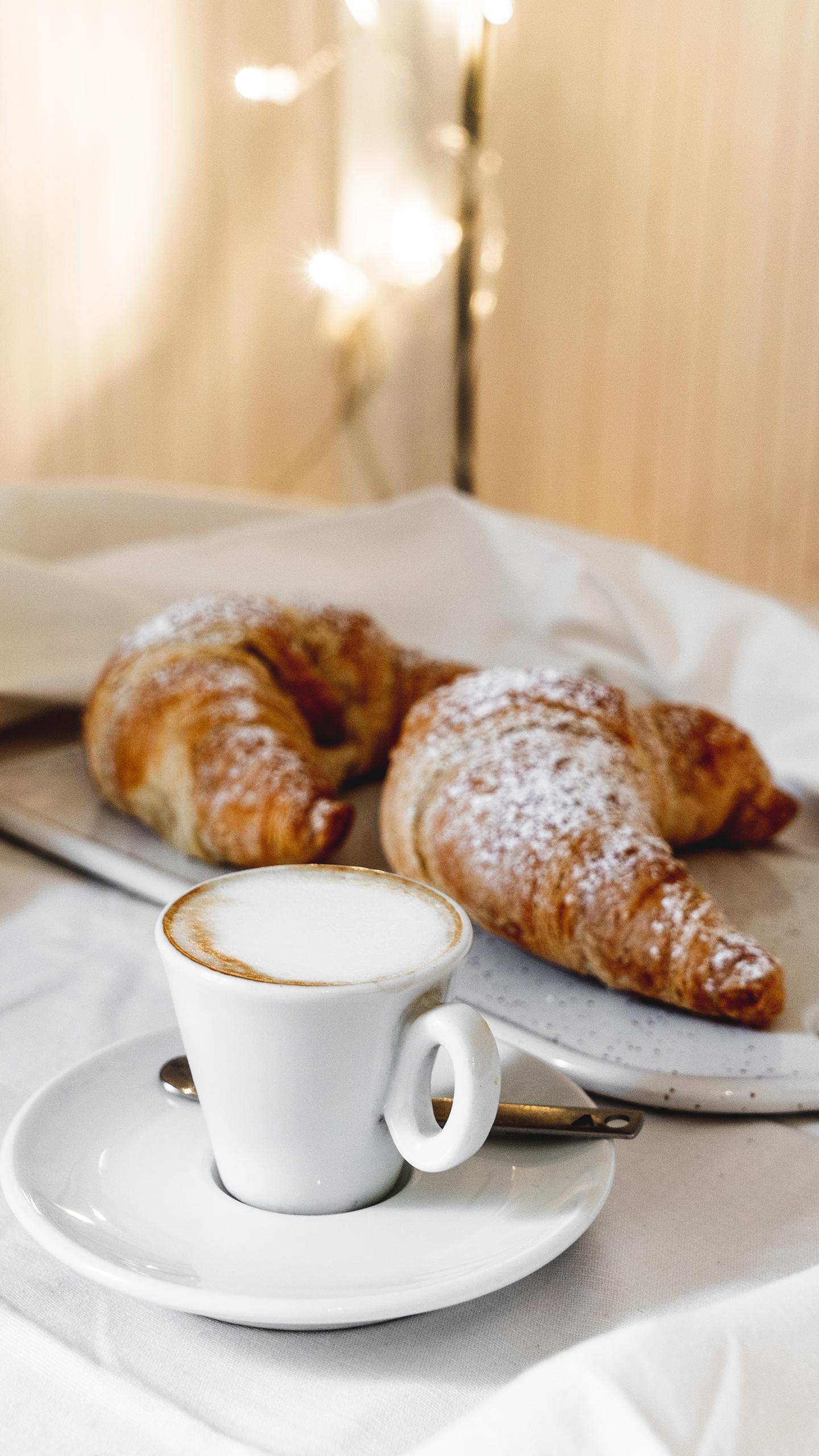 Un café est des croissants sont posés sur une table