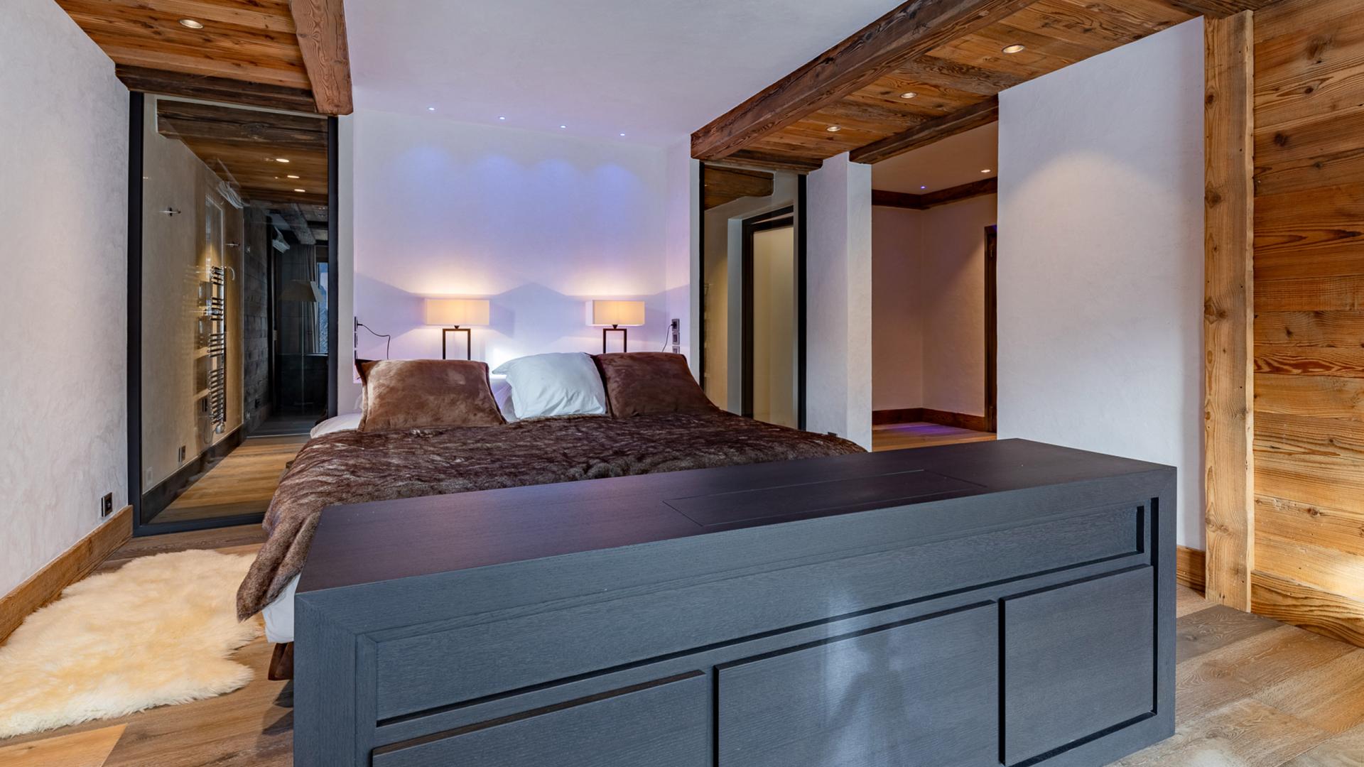 Lit avec derrière la salle de bains privative d'une des suites du Chalet Apsara à Méribel