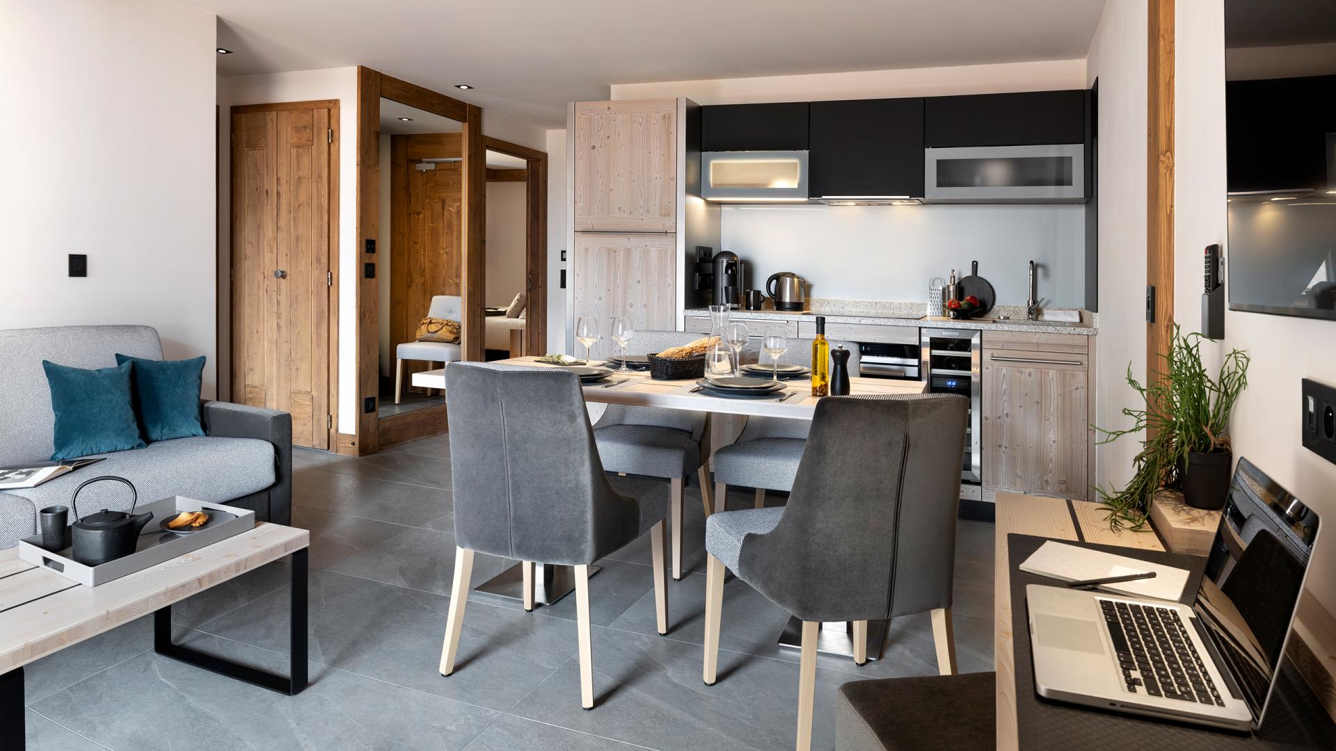 Pièce à vivre avec la cuisine en fond du 3P6 Prestige des Chalets Láska, situés aux Contamines-Montjoie