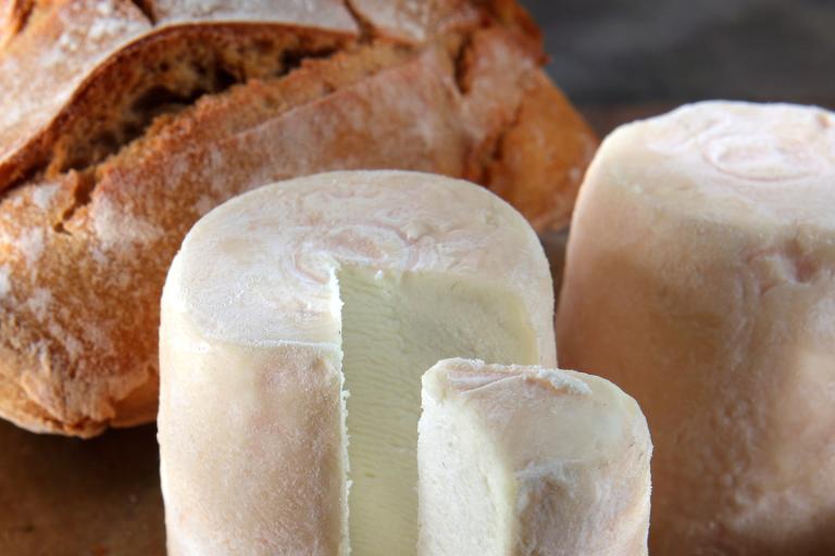 Plateau de fromages avec du pain sur une planche en bois