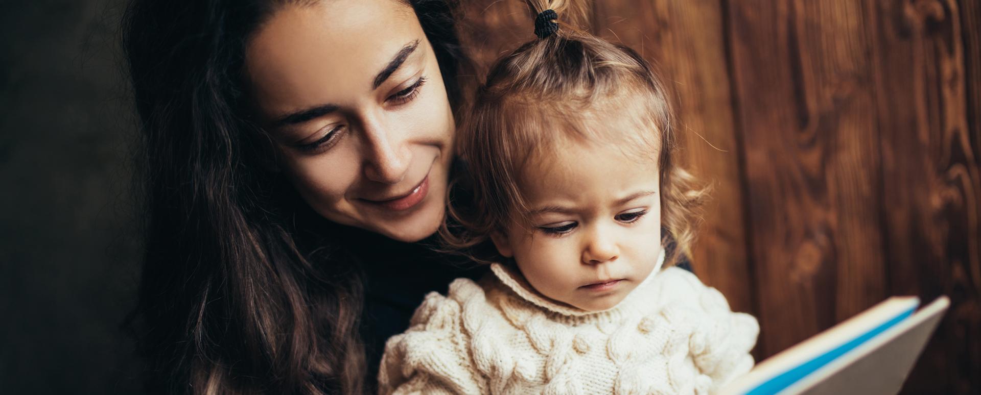 Une maman lit un livre à son enfant