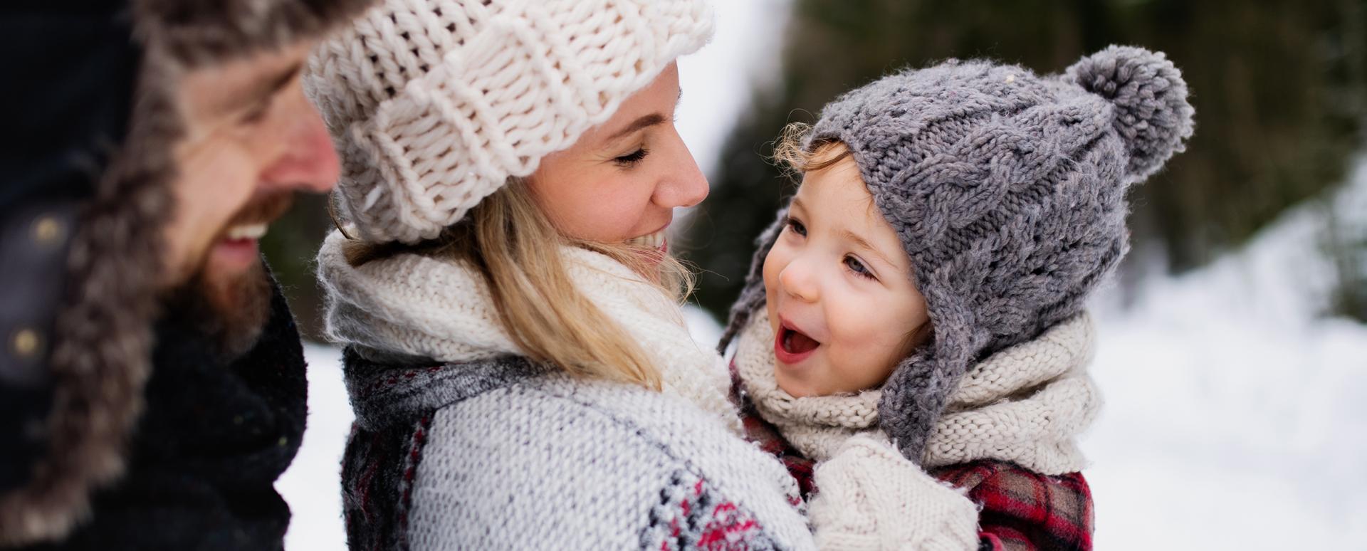 Des parents s'amusent avec leur jeune garçon dans la neige