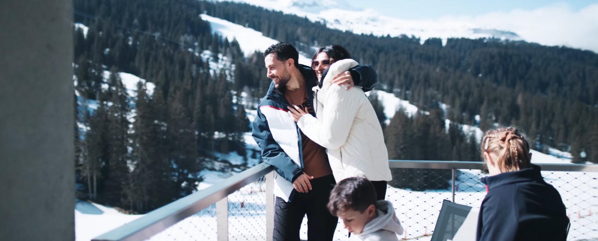 Vacances à la montagne en hiver, une famille profite du soleil sur le balcon de l'hôtel & résidence Alhéna à Flaine